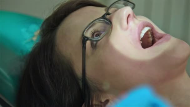 Frau lässt Zähne beim Zahnarzt untersuchen. Zeitlupeneffekt