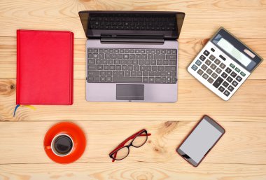 dizüstü bilgisayar, cep telefonu, gözlük ve kahve masada