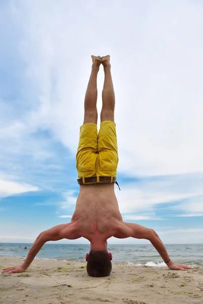 Hombre haciendo ejercicio de yoga de pie sobre la cabeza. Práctica de yoga . — Foto de Stock