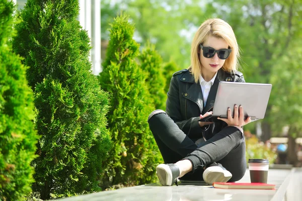 Meisje zit met een laptop — Stockfoto