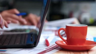 İşkadını oturan ofis ve dizüstü bilgisayarda yazarak