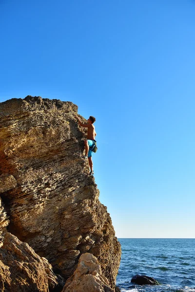 Ung man klättra upp på gula berg — Stockfoto