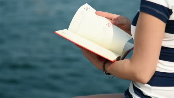 Csípő lány kezében tartsa vörös könyv — Stock videók