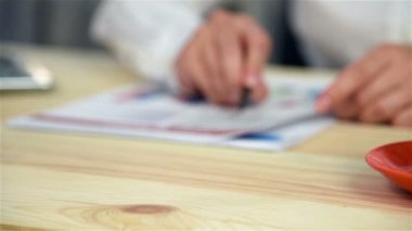 Fincan kahve odak. Kız gelir istatistikleri inceliyor. Ağır çekim etkisi
