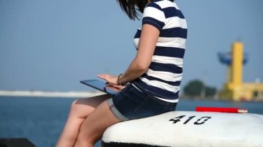 Dokunmatik yüzey limanda oturan kız. Ağır çekim etkisi