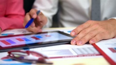 İş adamları iş grafikleri dijital tablet inceleyerek. Ağır çekim etkisi