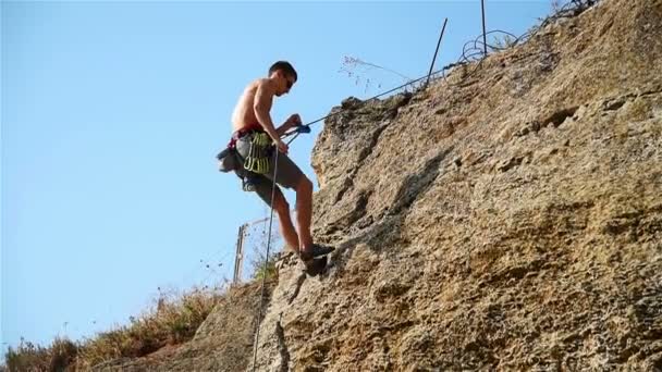 Alpinista extremo descendo de um penhasco em uma corda — Vídeo de Stock