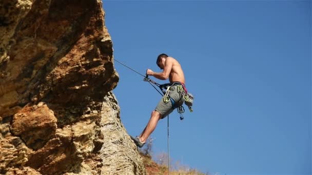 Экстремальный альпинист спускается с верёвки с утёса. Эффект медленного движения — стоковое видео
