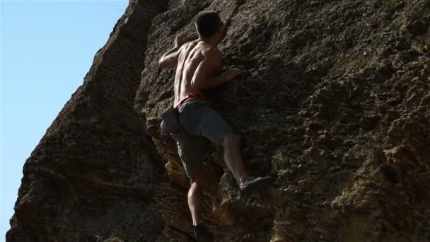 Fiatal extrém mászó, hegymászás, egy sziklán, biztosítás nélkül. Lassú mozgás hatása — Stock videók