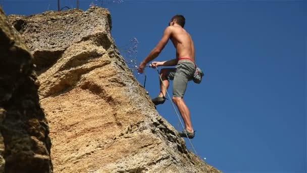 Extremkletterer klettert an einem Seil von einem Felsen — Stockvideo