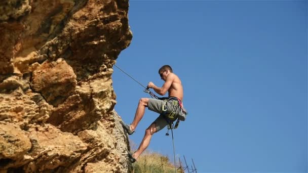 Rock Climber Descende uma corda de um penhasco. Efeito de movimento lento — Vídeo de Stock