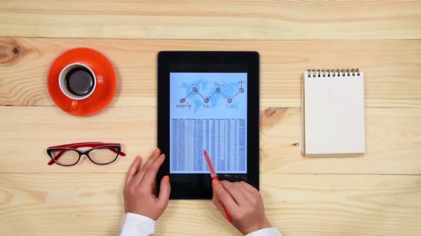 Бизнесмен анализирует финансовый отчет с помощью планшета на деревянном столе в офисе — стоковое видео