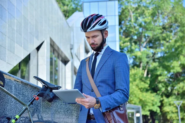 Businessman with bike using digital tablet computer in park. Business And Urban Style Concept. Slow Motion Effect.