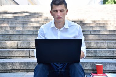 Dışarıda dizüstü bilgisayarda çalışan bir iş adamı. İş ve eğitim kavramı. Kapat.