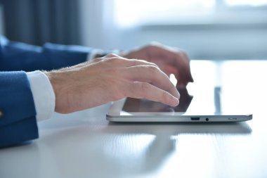 İşadamı ofisinde oturuyor ve ekranda hisse senedi raporuyla dijital tablet kullanıyor. İş ve başarı kavramı.