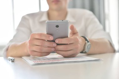 Akıllı telefonlu mali denetçi verileri analiz ediyor ve iş planlarını kontrol ediyor. Yatırım ve finansal konsept.