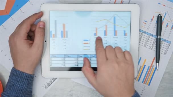ブローカーハンドのトップビューデジタルタブレット画面上のビジネスレポートを分析します 金融と貿易の概念 スローモーション効果 — ストック動画
