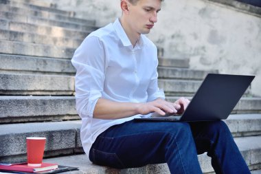 Dışarıda dizüstü bilgisayarda çalışan bir iş adamı. İş ve eğitim kavramı. Kapat.