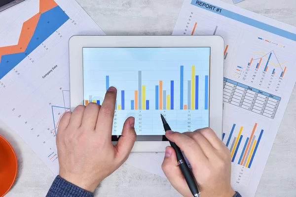 Belgeler dijital tablet ekranla çalışan işadamlarının üst görünümü. Finans ve ticaret konsepti. Kapat.