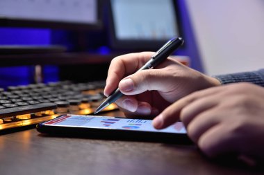 Akıllı telefon kullanan borsacı ve rapor verilerini kontrol ediyor. Finans ve ticaret konsepti. Kapat.