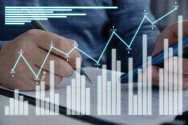 Businessman checks financial report with statistics and investment analytic hologram. Internet trading and business  concept. Close up