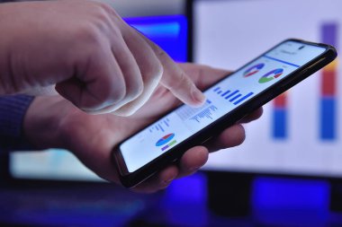 Akıllı telefon kullanan ve iş raporlarını analiz eden iş adamları. İş ve finansal başarı kavramı. Kapat.
