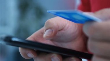 Eller kredi kartı detaylarını satın almak için cep telefonuna girer. Çevrimiçi alışveriş ve iş kavramı. Kapat.