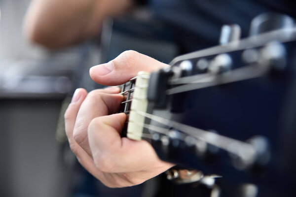 Man playing on semi-acoustic guitar. Music and art concept. Close up