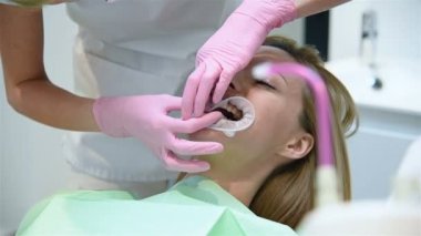 Ortodontist hastanın ağzına ağız halkası takıyor. Sağlık ve Stomatoloji Konsepti