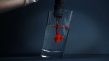 Dövme Makinesi Temiz Bardakta Kırmızı Mürekkep İğnelerini Temizliyor. Sanat ve Tasarım Konsepti. Kapat.