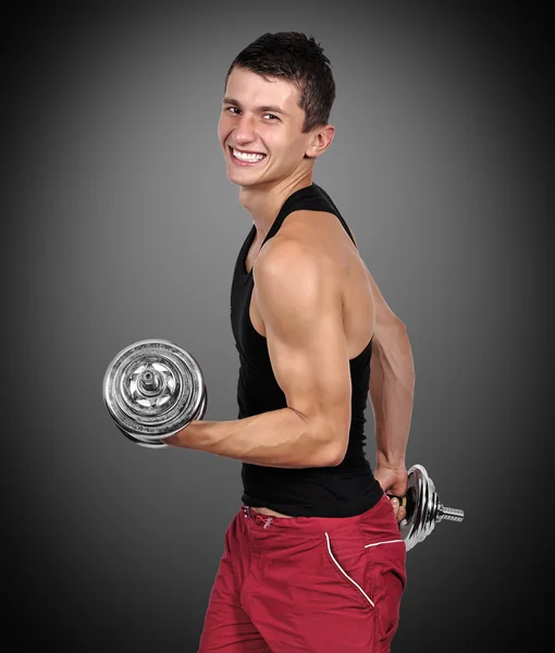 Muskelkräftiger Mann, der Hanteln hebt — Stockfoto