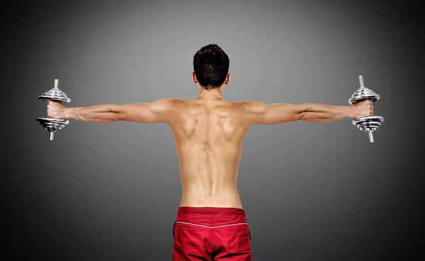 Muscular man lifting dumbbells — Stock Photo, Image