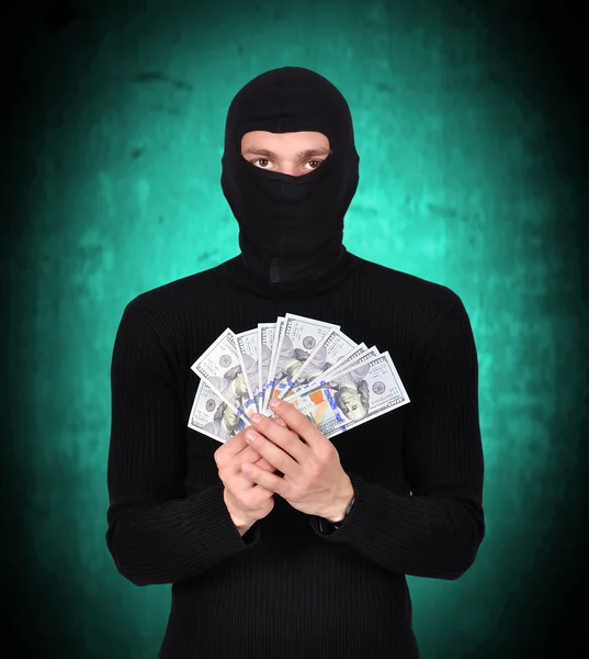 Mann mit Maske hält Dollar in der Hand — Stockfoto