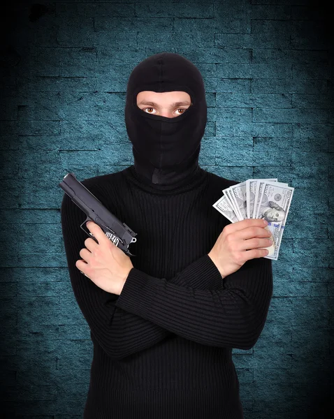 Terrorist holding gun and dollars — Stock Photo, Image