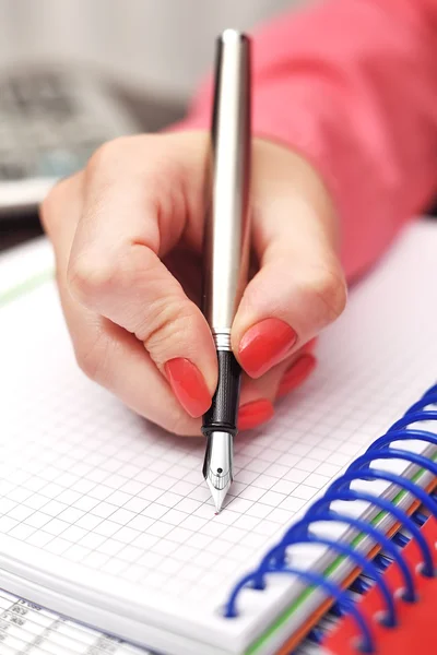 Vrouwelijke hand met inkt pen — Stockfoto