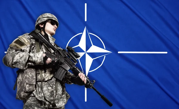 Soldat på Natos flagga bakgrund — Stockfoto