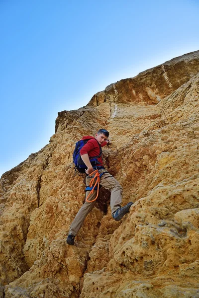 Man climbing on yellow rock — Stock Photo, Image