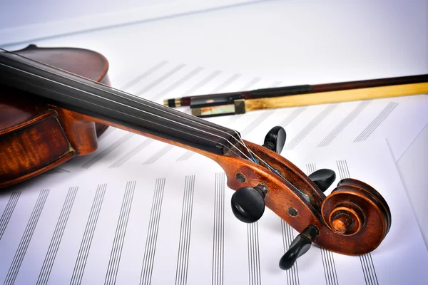 Violin lying at an angle on the notes — Stock Photo, Image