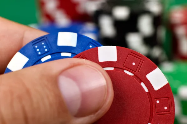 Fingers holding two poker chips — Stock Photo, Image