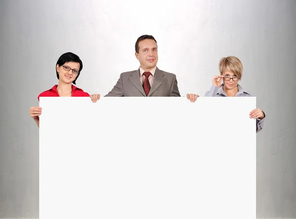 Empresários segurando cartaz em branco — Fotografia de Stock