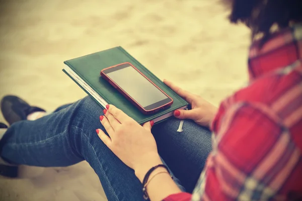 Хипстерская девушка с книгой и мобильным телефоном — стоковое фото