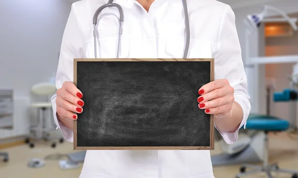 Doctor holding blank chalk board — Stock Photo, Image