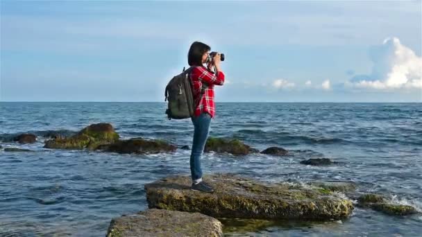 Хіпстерська дівчина фотографує море — стокове відео