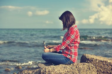 kayanın üzerinde oturan defter ile kız