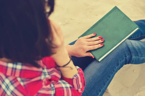 Hipster meisje, zittend met boek en cellphone — Stockfoto