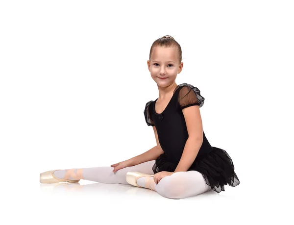 Junge Balletttänzerin in schwarzem Tutu sitzt auf dem Boden — Stockfoto