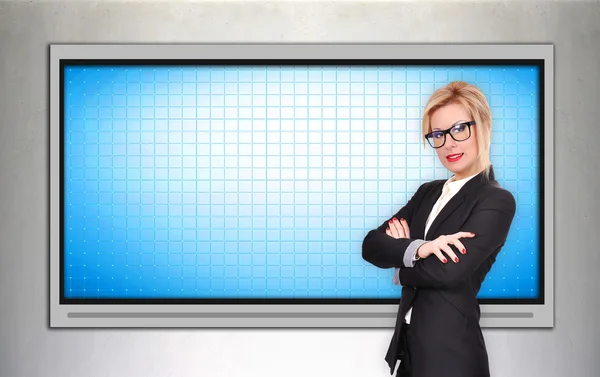 Business woman standing near blank plasma tv — Stock Photo, Image