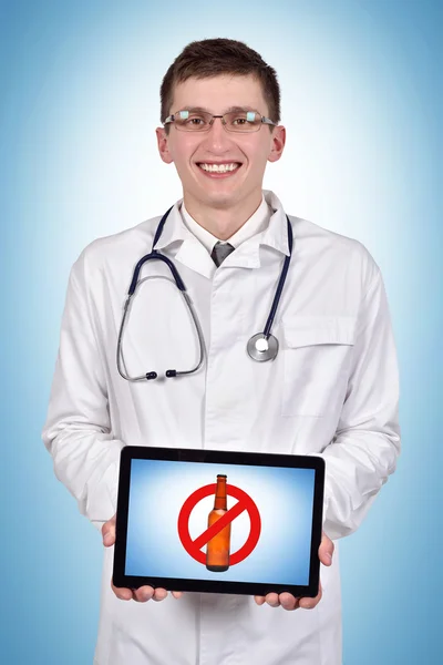 Doktor drží touch pad s zastávku alkoholem na modrém pozadí — Stock fotografie