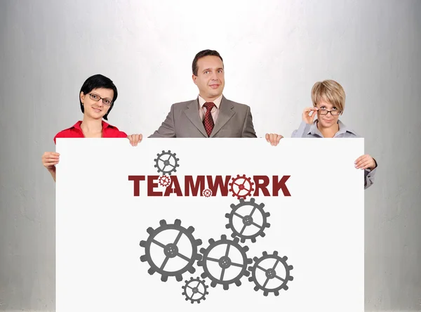 Businesspeople holding poster with teamwork concept — Stock Photo, Image