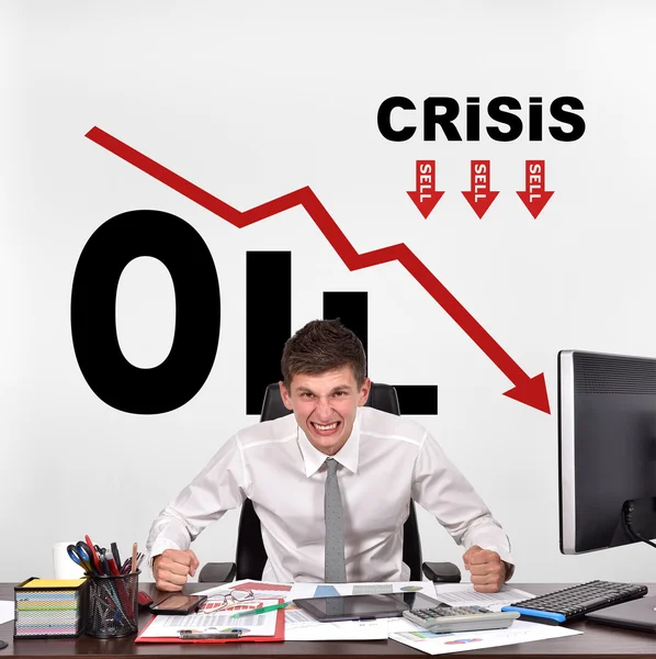 Uomo d'affari arrabbiato seduto a tavola in ufficio e disegno crisi petrolifera sul muro — Foto Stock
